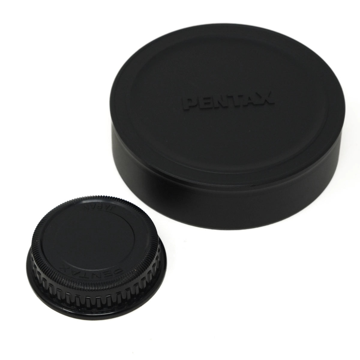 Two black camera lens caps with Pentax branding on a white background