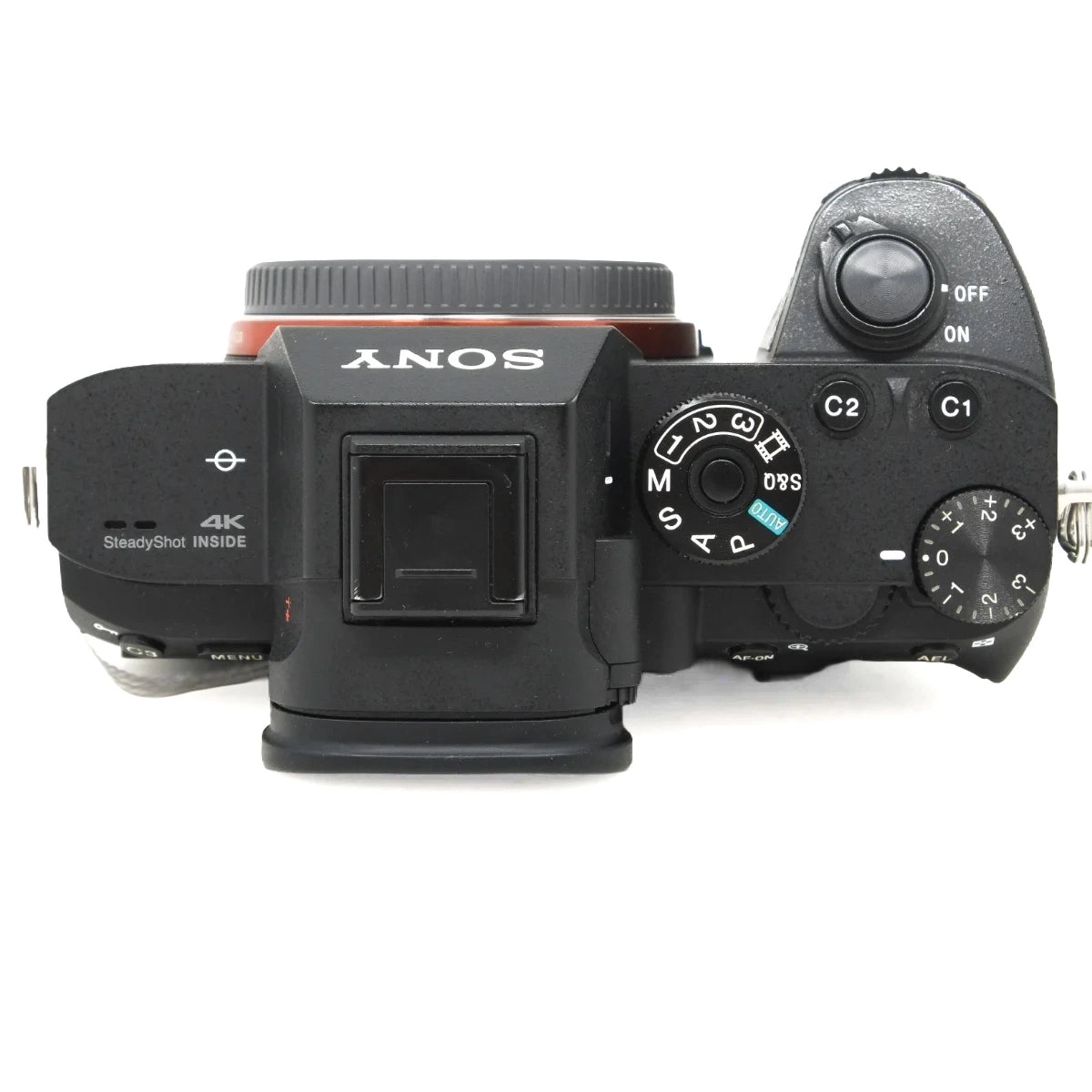Sony mirrorless camera body top view with attached lens, showing control buttons, dials, and the SONY branding on a white background.