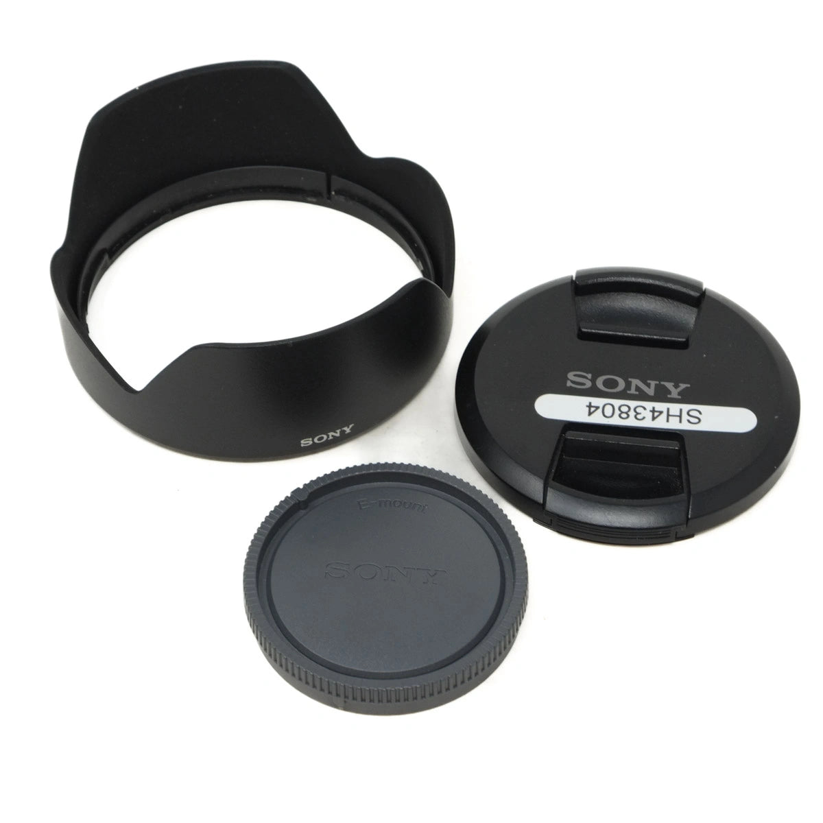 Sony camera lens cap, hood, and body cap on a white background
