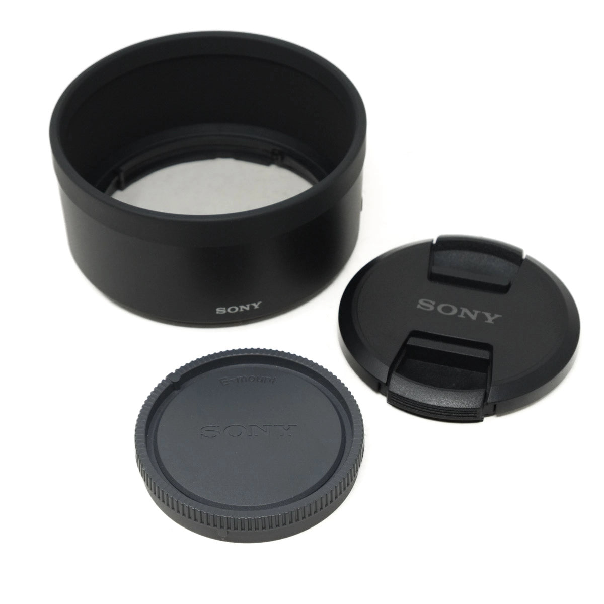 Sony lens cap, front cover, and lens hood on a white background