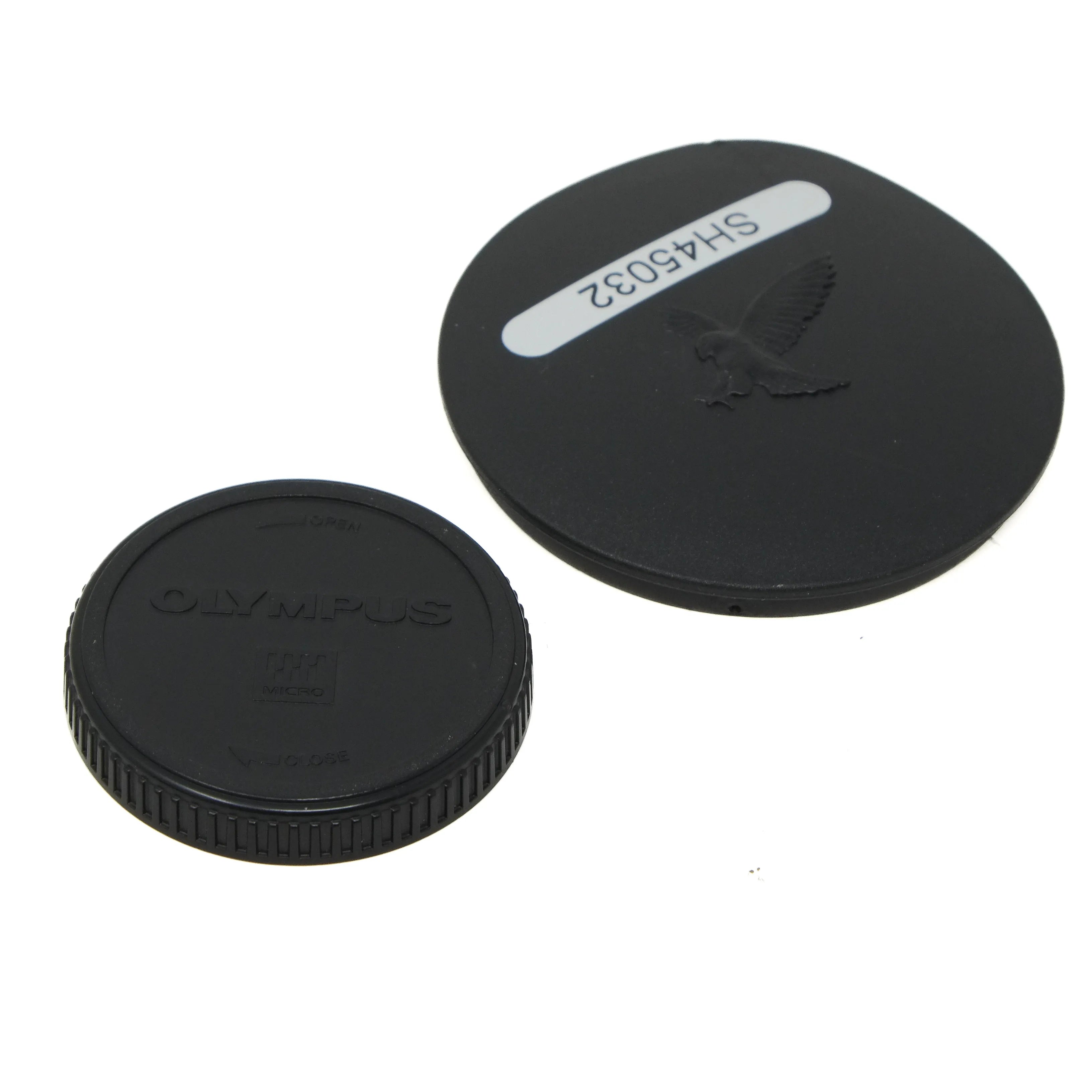 Two black camera lens caps with 'Olympus' branding on a white background