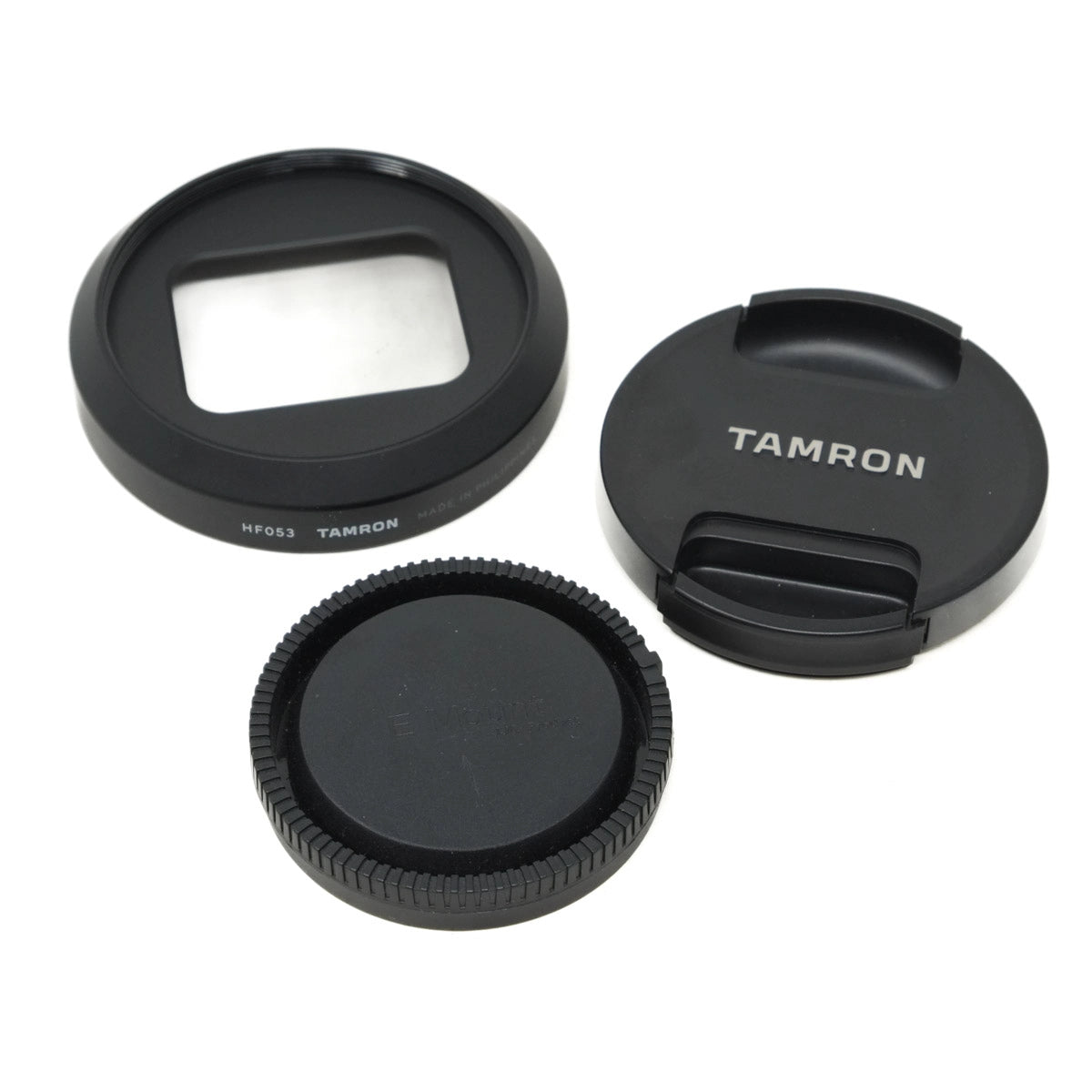 Three camera lens caps with 'Tamron' branding on a white background