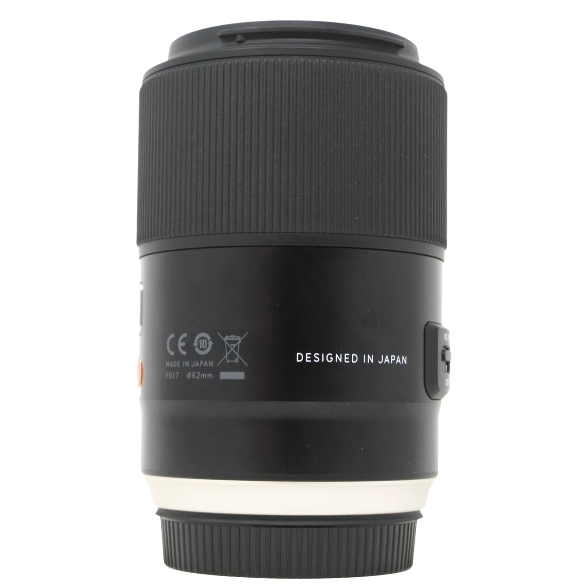 A black camera lens with white text reading 'DESIGNED IN JAPAN' and small regulatory markings, shown on a plain white background.
