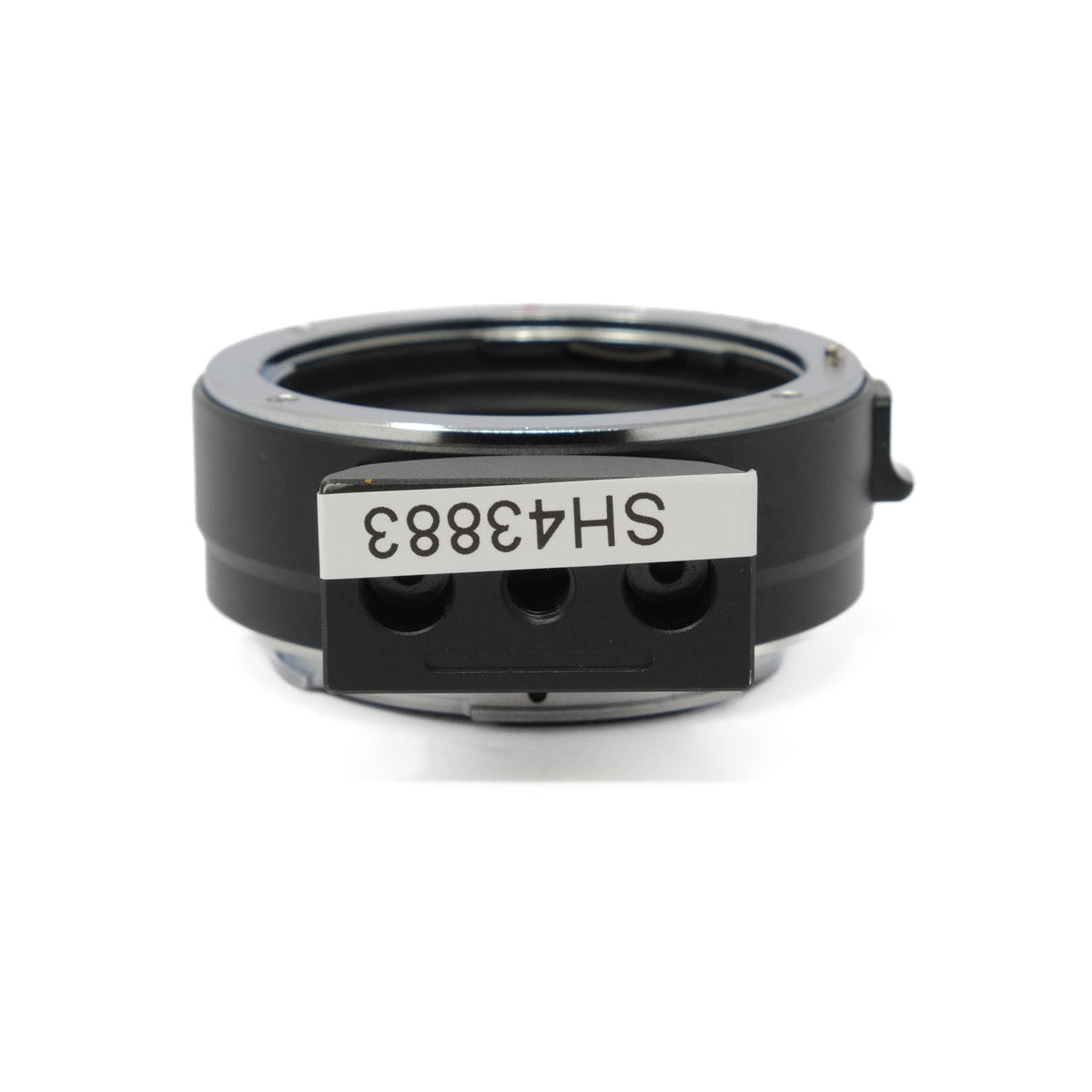 Black camera lens mount adapter with a label on a white background