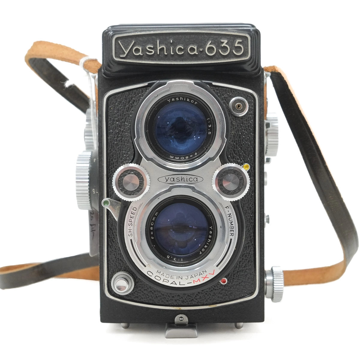 Vintage Yashica 635 camera with leather straps on a white background