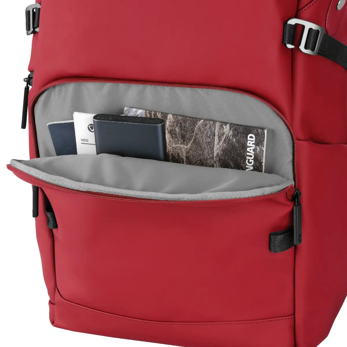 Red backpack with open front pocket showing items inside