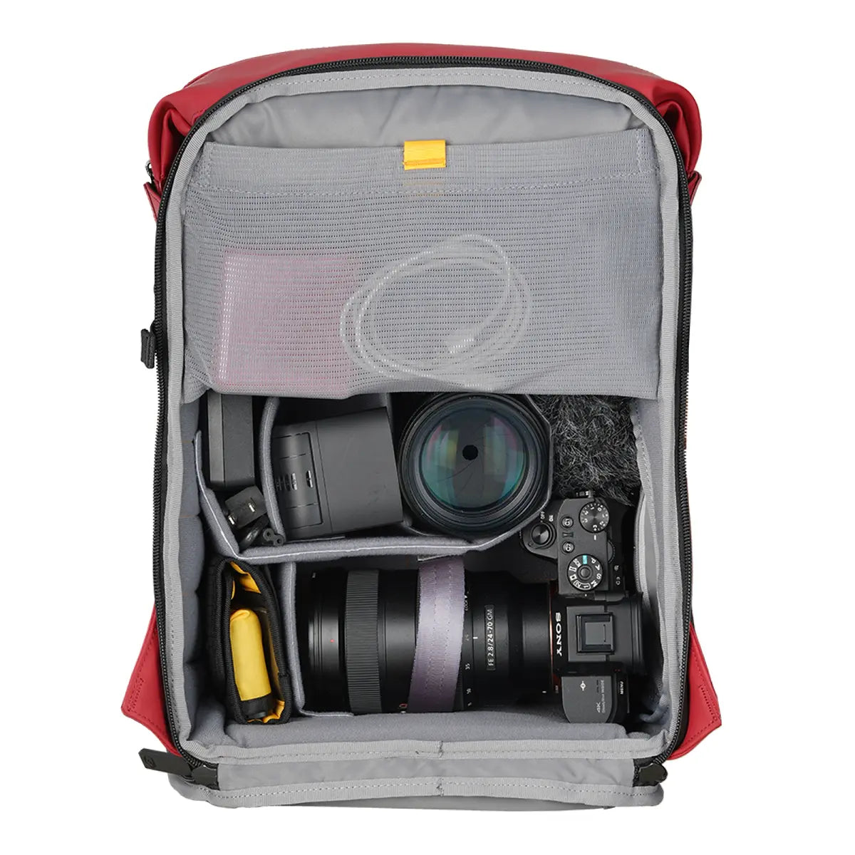Camera equipment including lenses and a camera body inside a red and gray backpack.
