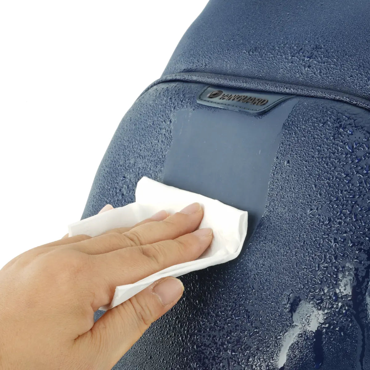 Hand cleaning a blue textured surface with a white cloth