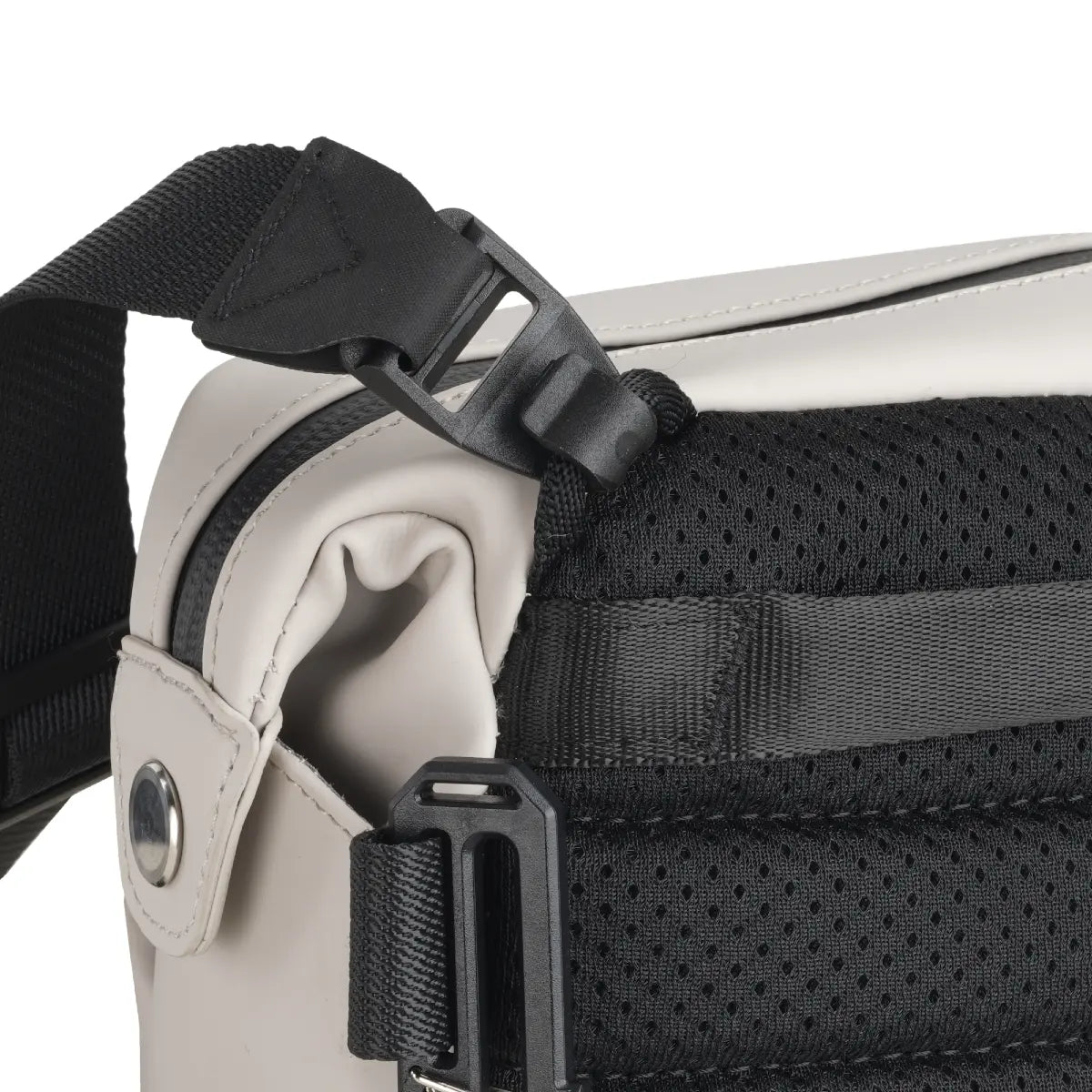 Close-up of a beige and black bag with a strap and zipper detail on a white background
