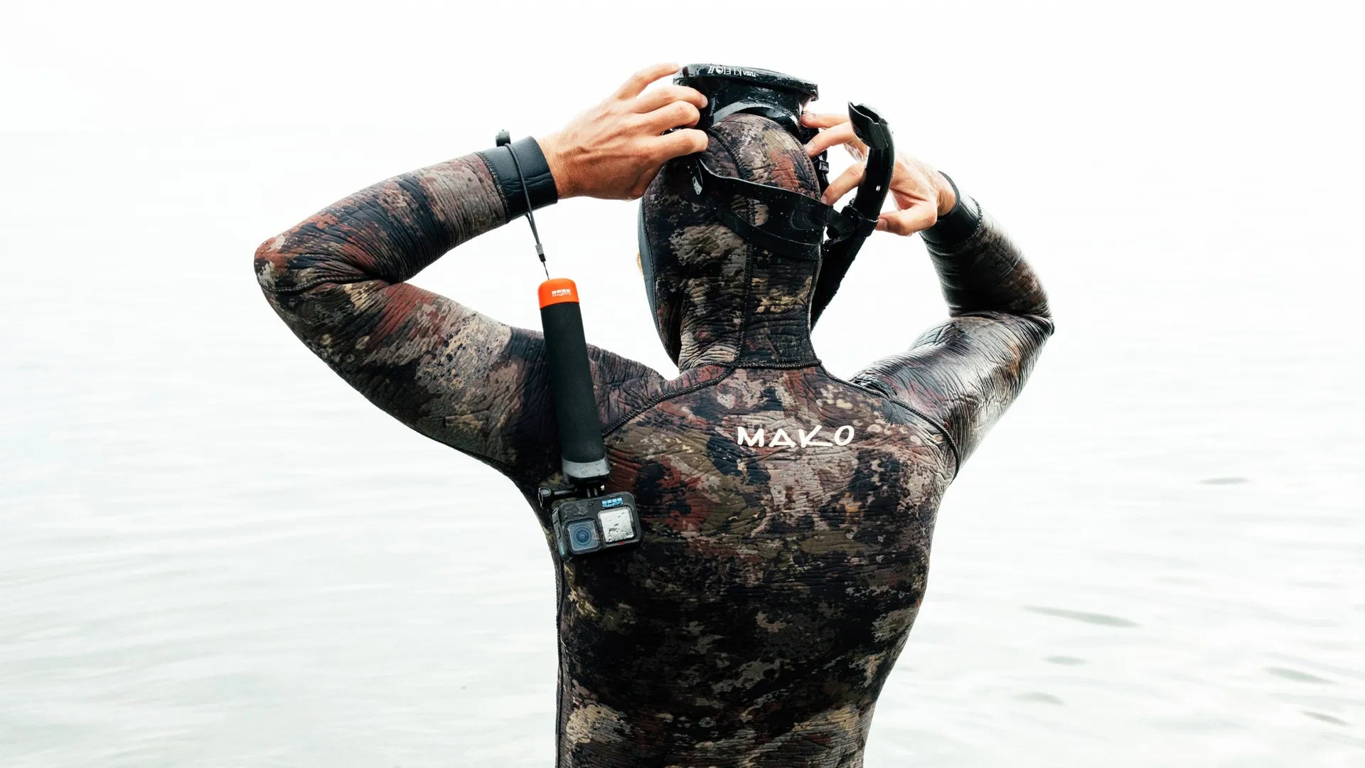 Lifestyle shot of a snorkler about to swim whilst using the gopro handler grip