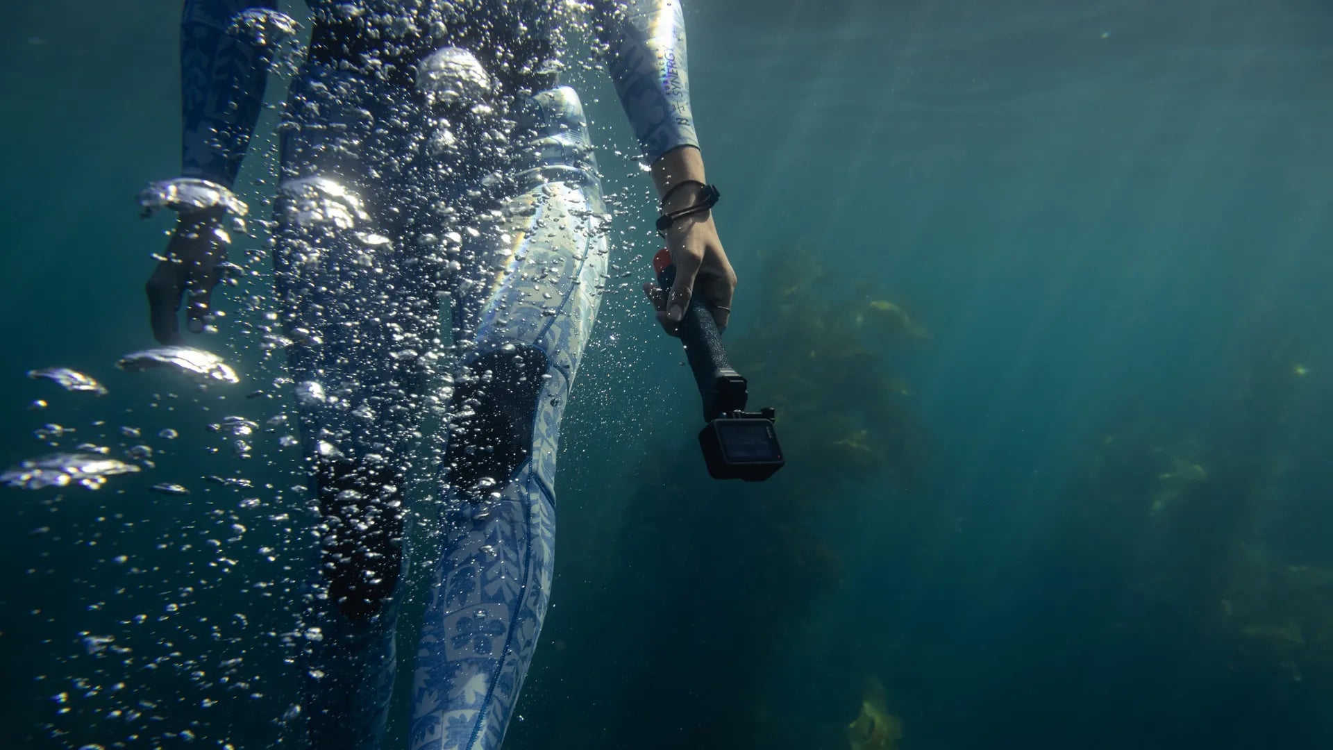 Lifestyle underwater shot of a snorkler with bubbles and seaweed in the background