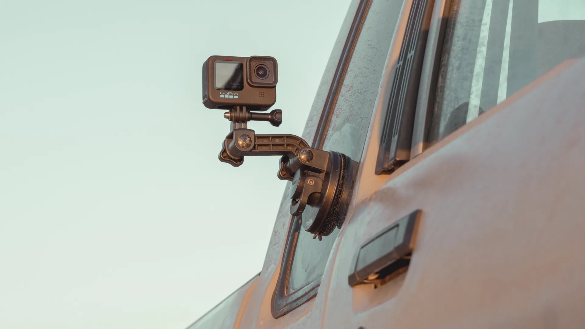 Lifestyle shot of the camera attached to the side of a pickup truck at sunset
