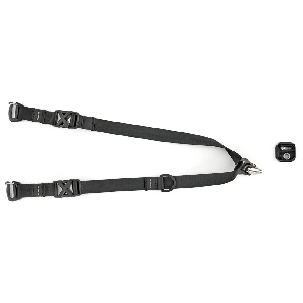 A black Y-shaped sling strap with quick-release plastic buckles and metal loops, shown on a plain white background with a small black tripod plate at the right.