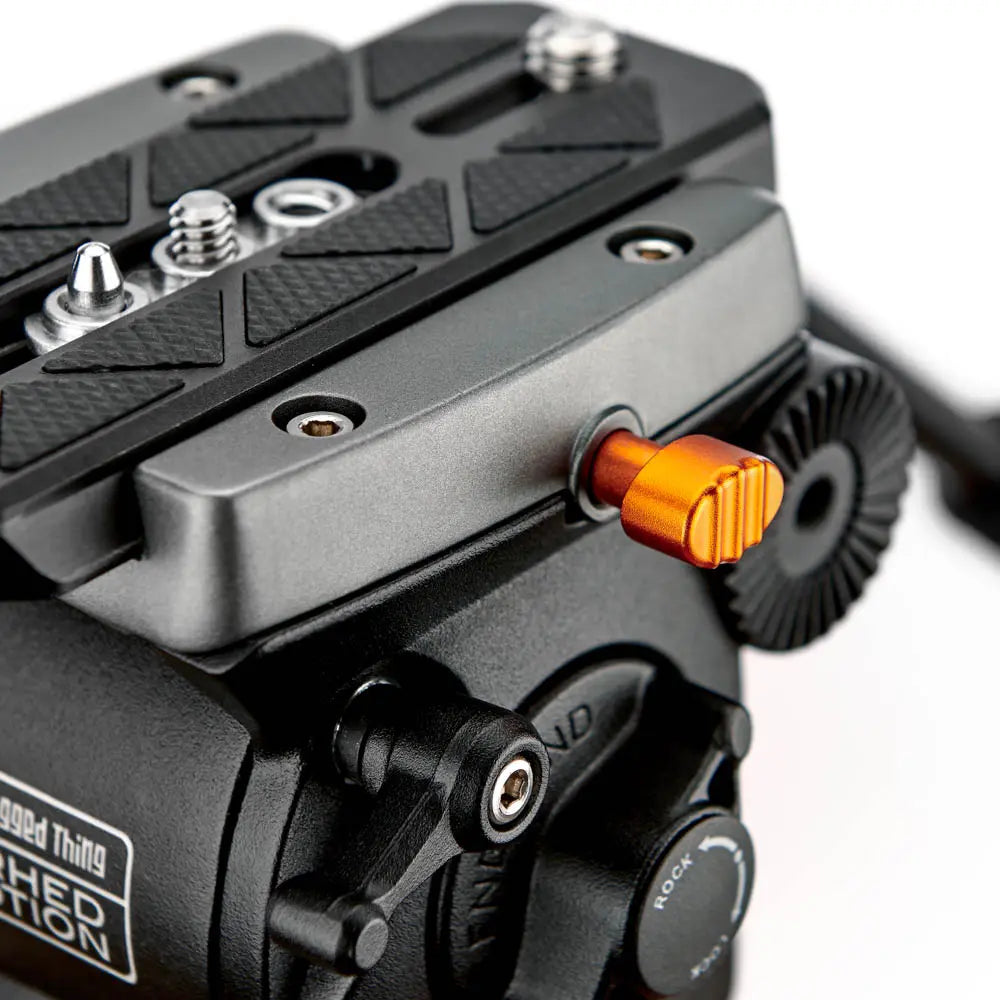 Close-up of a camera mount with an orange button on a white background