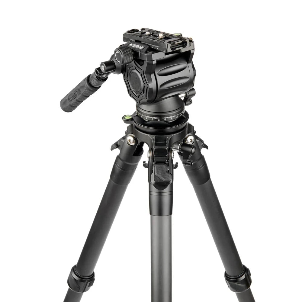 A black video camera tripod with a fluid head and carrying handle, photographed on a seamless white background.