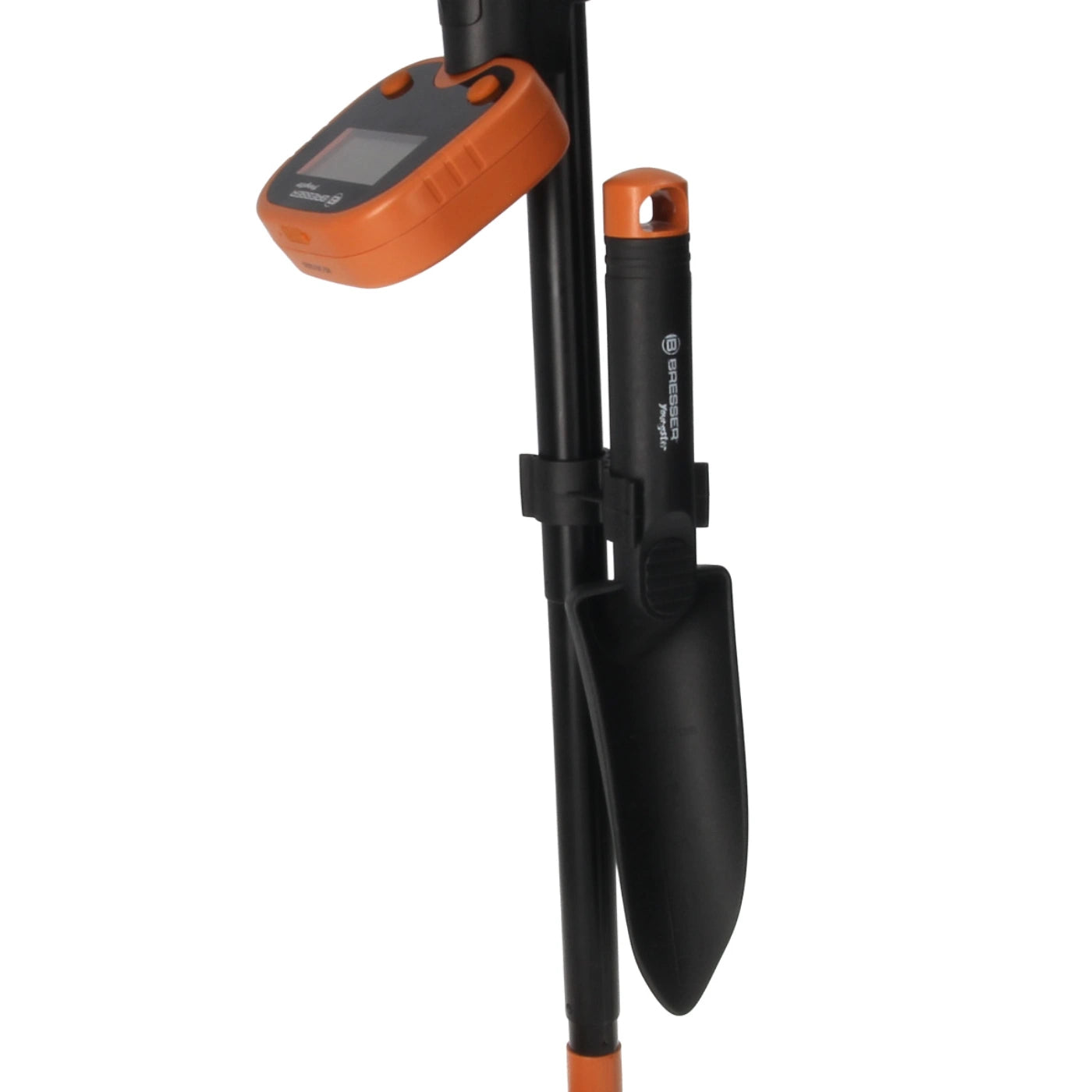 A black and orange electronic metal detector with a digital display screen, shown alongside a black hand trowel in a matching black sheath on a white background.