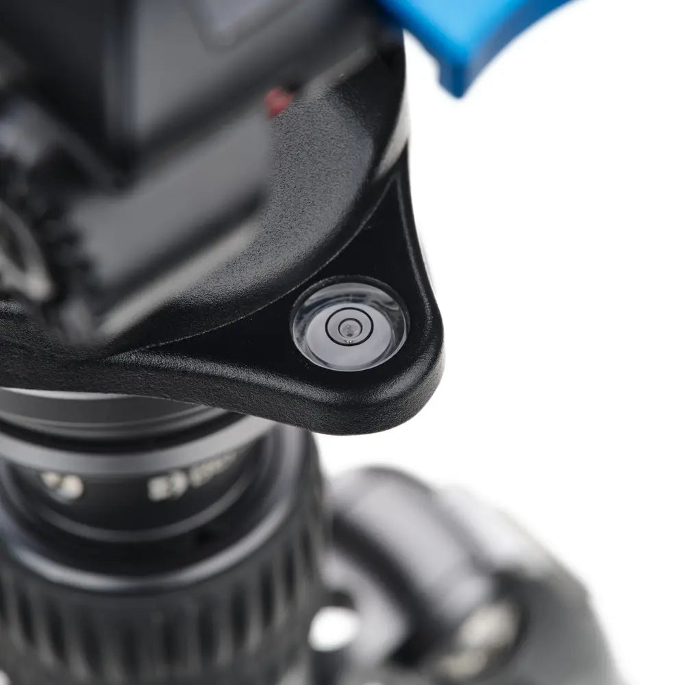 Close-up of a camera lens and tripod on a white background