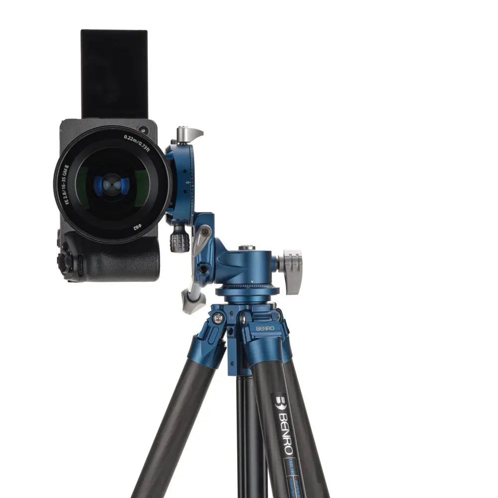 Camera with lens and Benro tripod on a white background