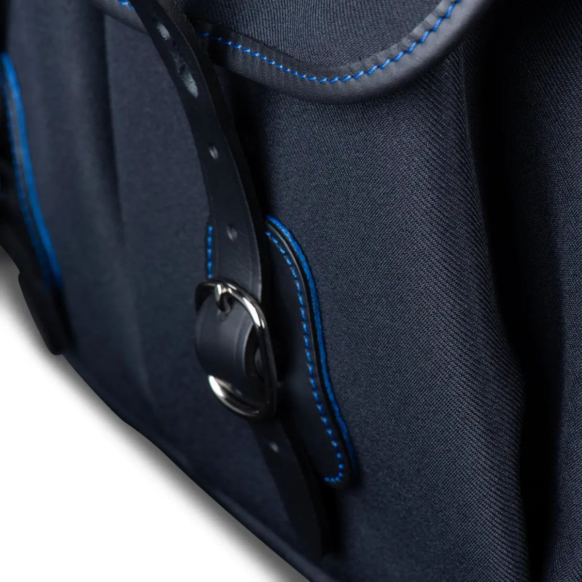 Close-up of a dark blue bag with blue stitching on a white background