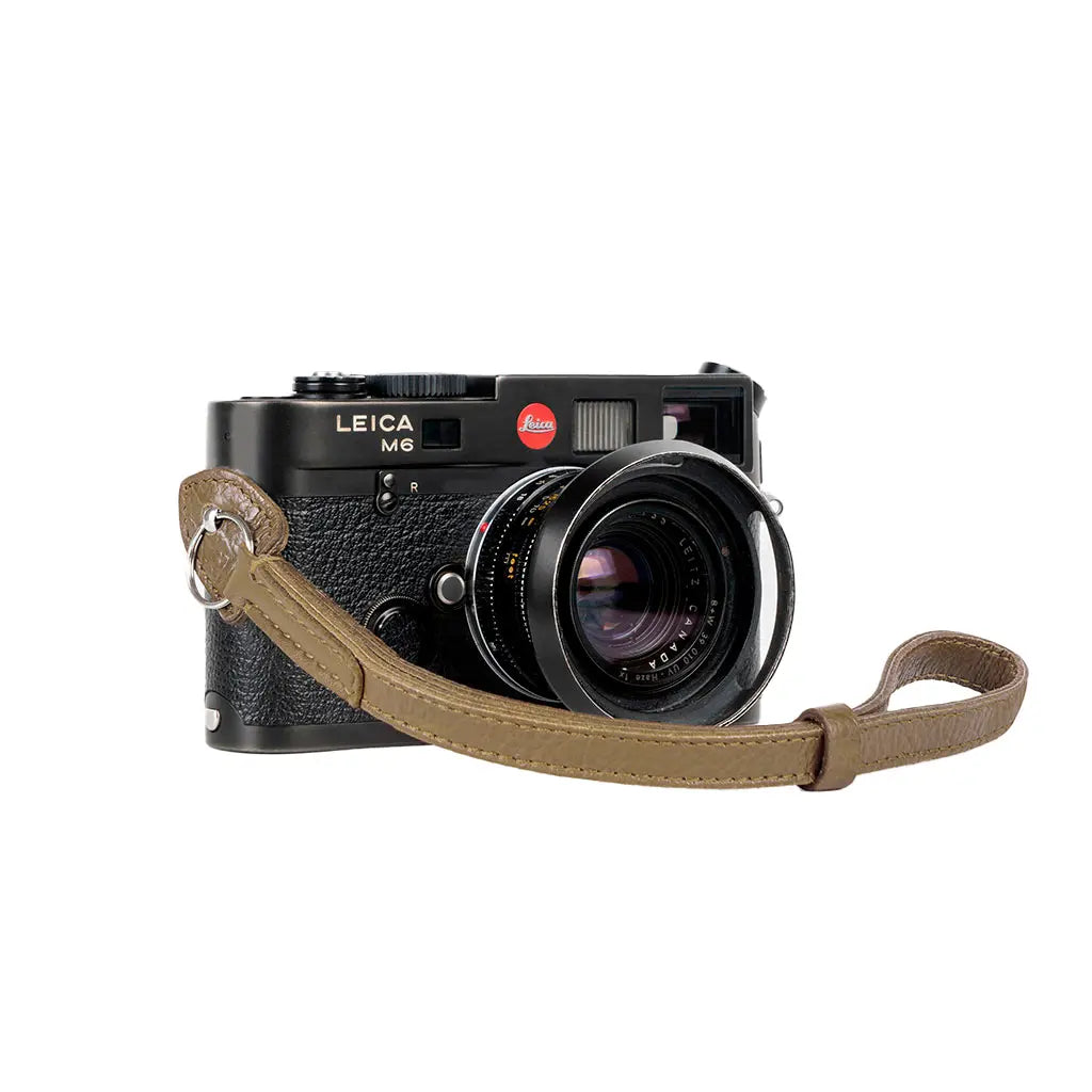 Leica camera with a brown strap on a white background