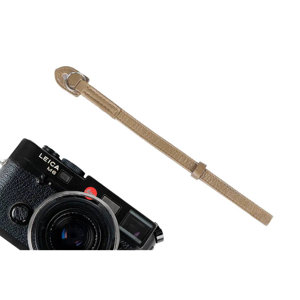 Leica camera with a brown strap on a white background