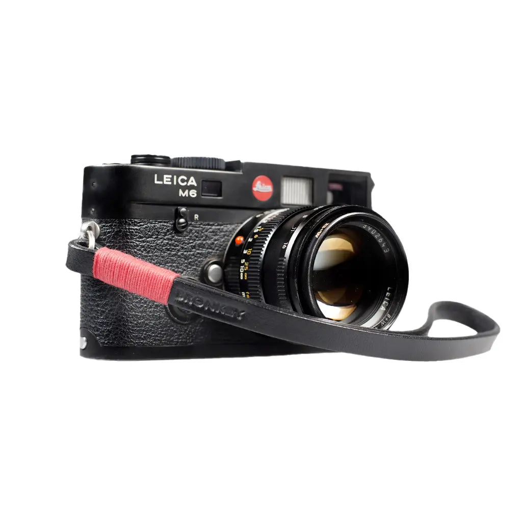 Leica camera with a red strap on a white background