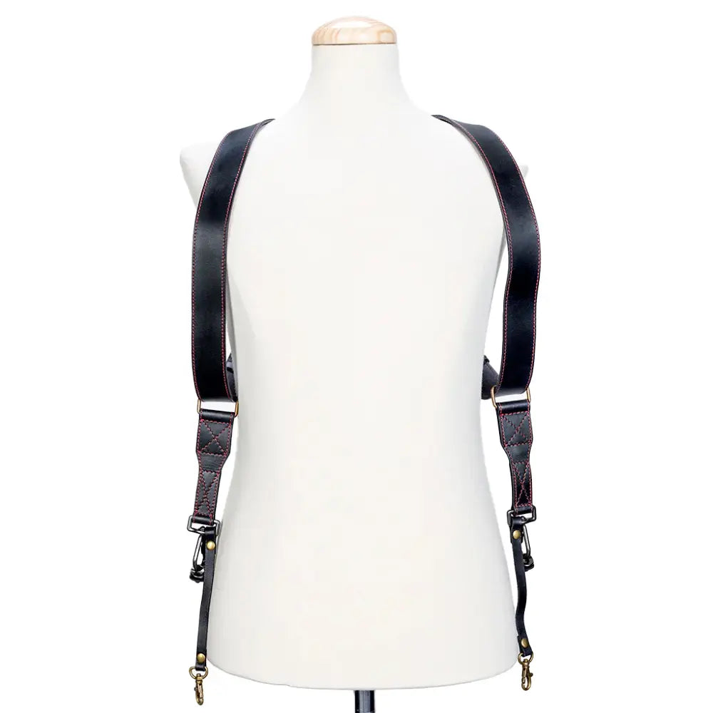 Black leather suspenders on a mannequin against a white background
