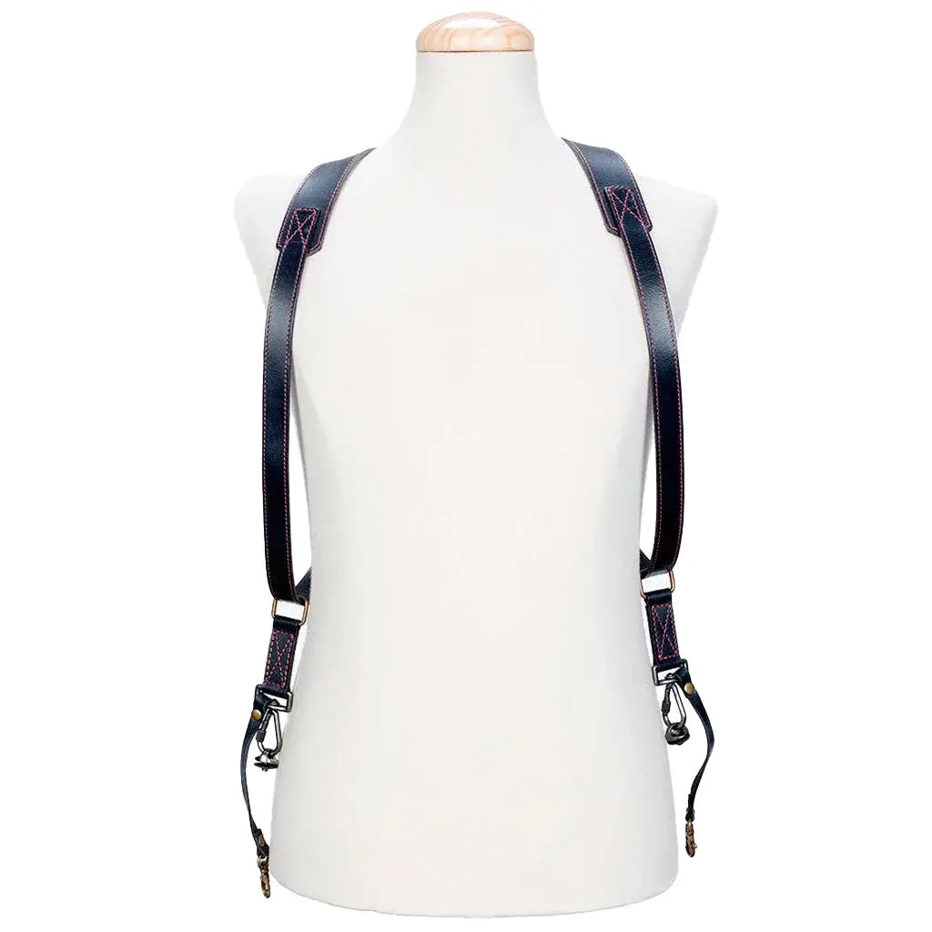 Black leather suspenders on a mannequin with a white background