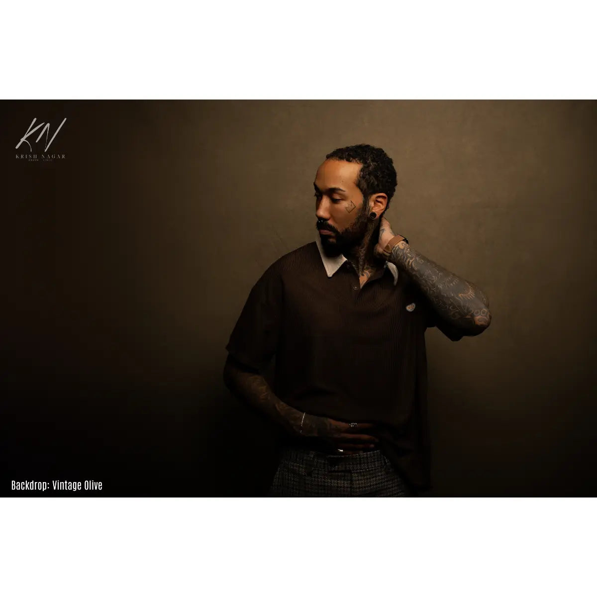Man posing against a vintage olive backdrop
