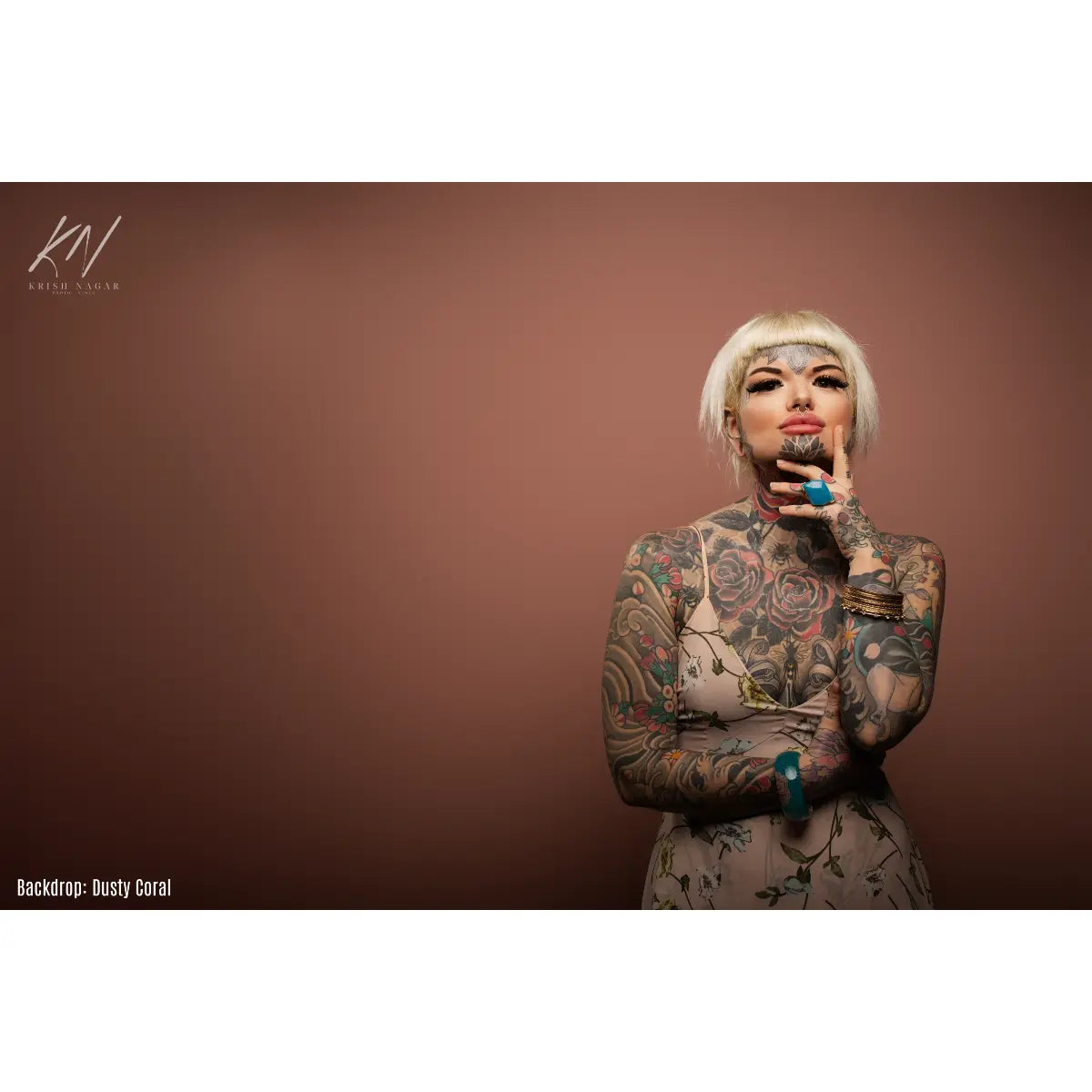 Woman with tattoos against a brown backdrop