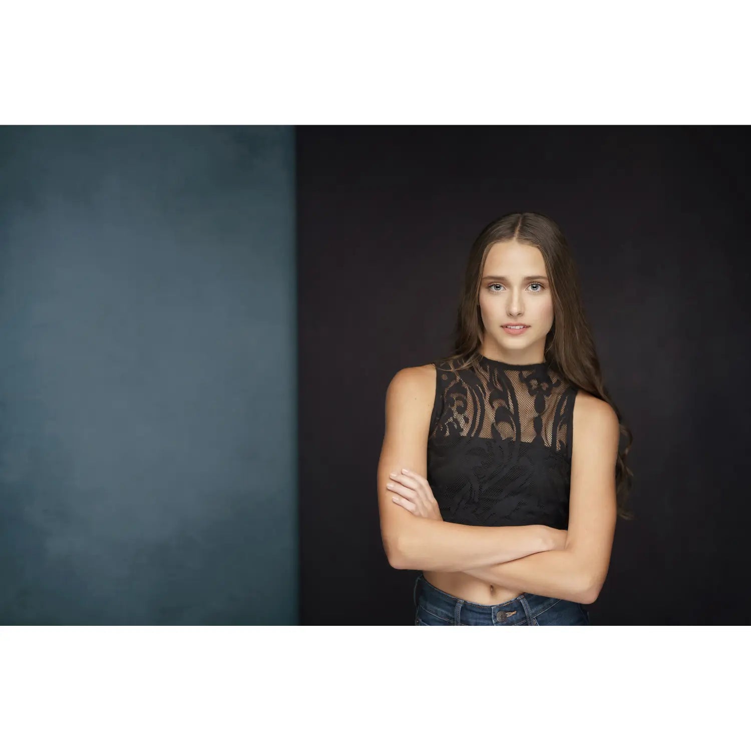 Woman wearing a black lace top against a dark background