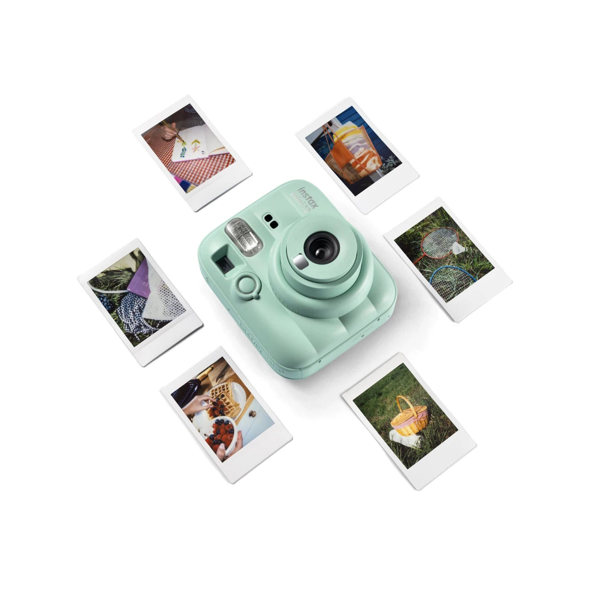 Mint green instant camera with instant photos on a white background