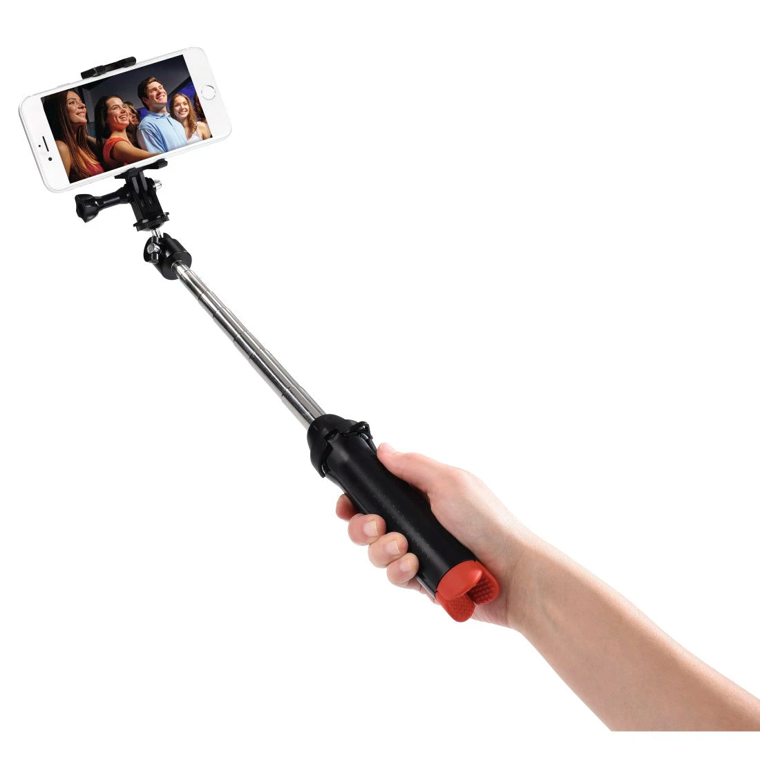 Hand holding a black and red selfie stick with a smartphone displaying a photo of four people.
