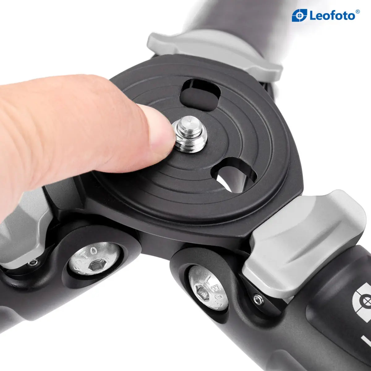 Hand adjusting a camera mount on a Leofoto tripod