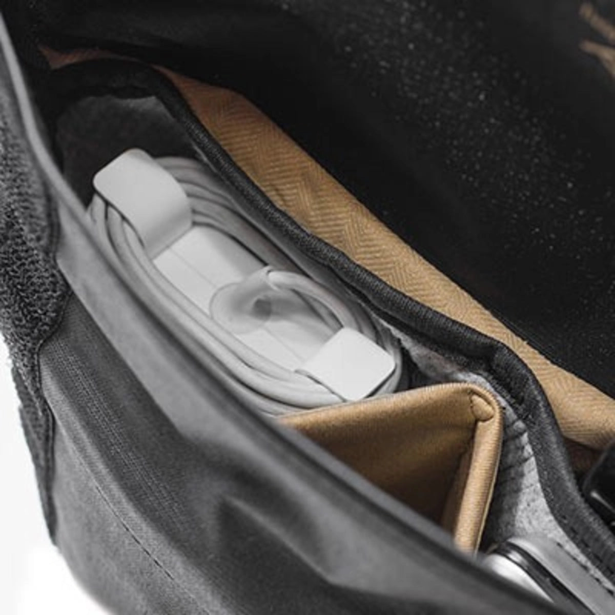 Close-up of a bag with compartments containing white items and a brown interior.
