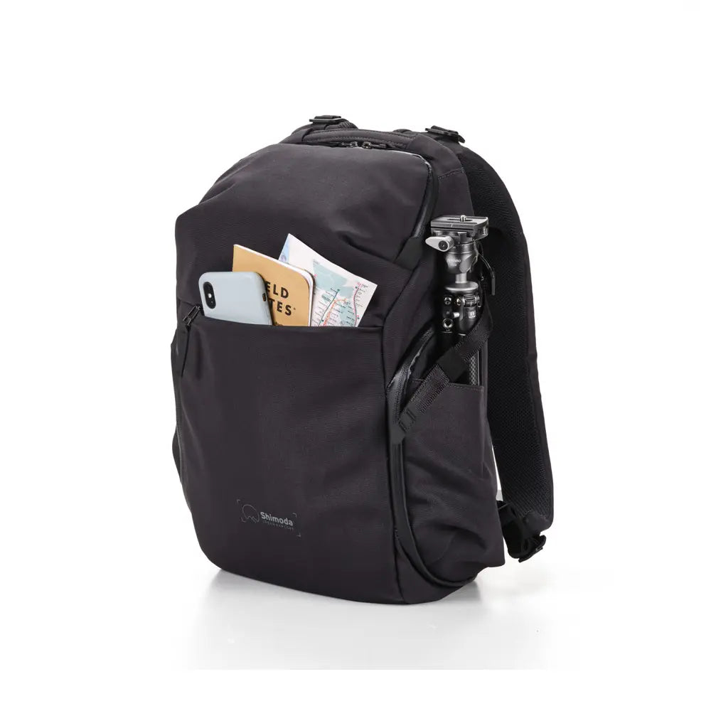 Black backpack with items in front pocket on a white background