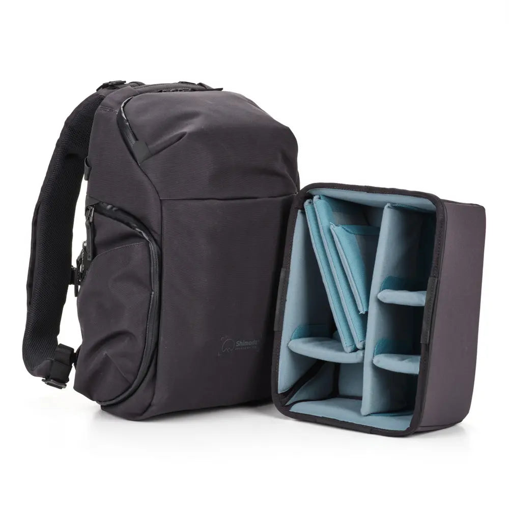 Black backpack with open compartment showing blue dividers on a white background