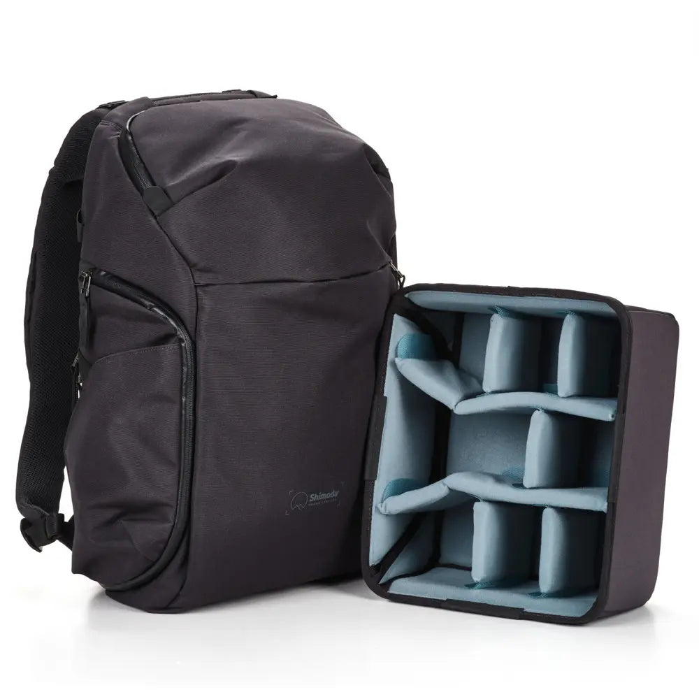 Black backpack with a compartment showing blue dividers on a white background