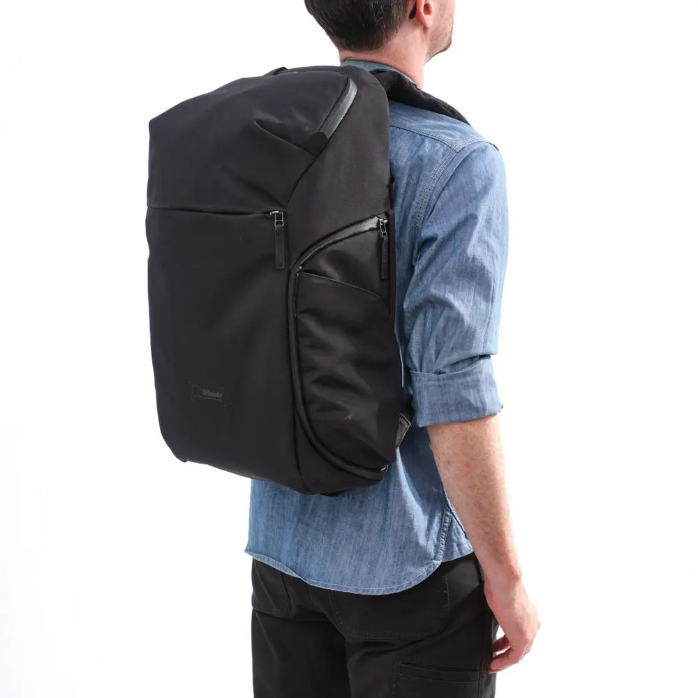 Person wearing a black backpack on a white background
