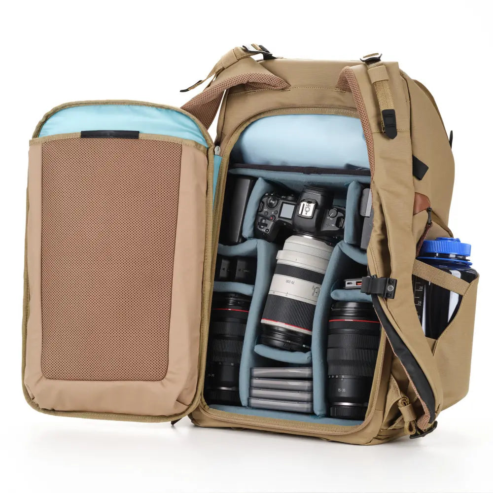 Open beige backpack with camera equipment on a white background