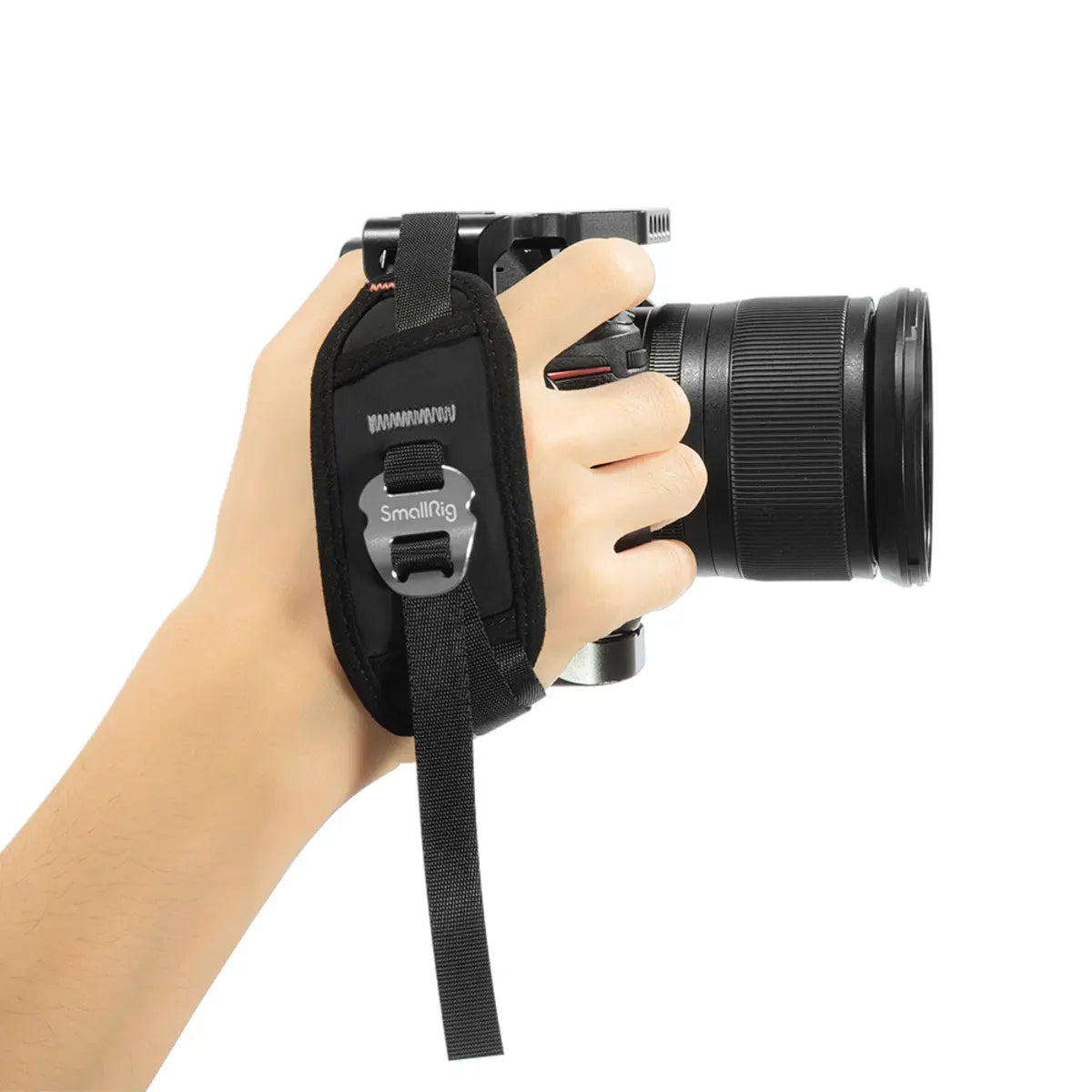 Hand holding a camera with a strap labeled 'SmallRig' on a white background