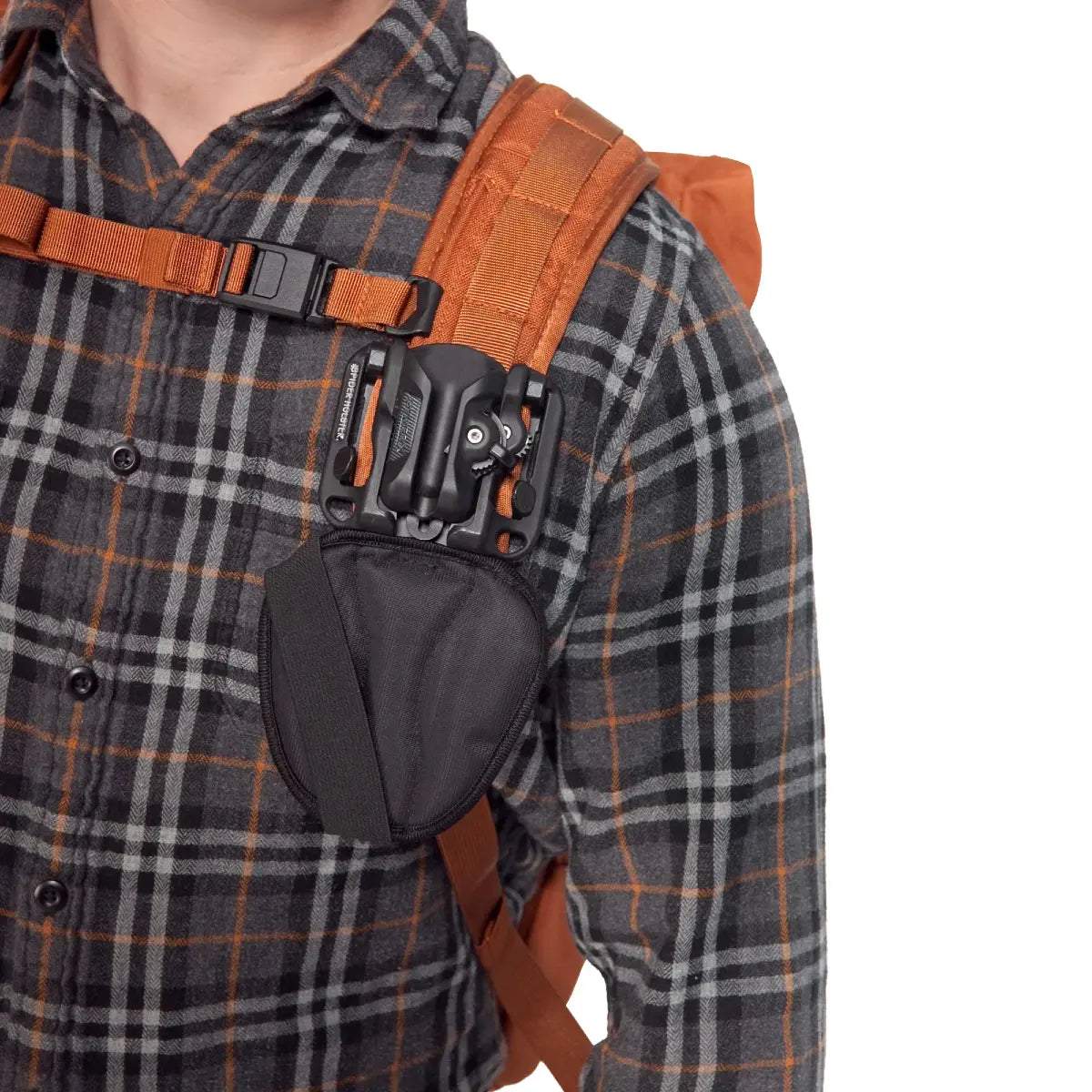 Person wearing a plaid shirt with an orange backpack strap and black pouch.