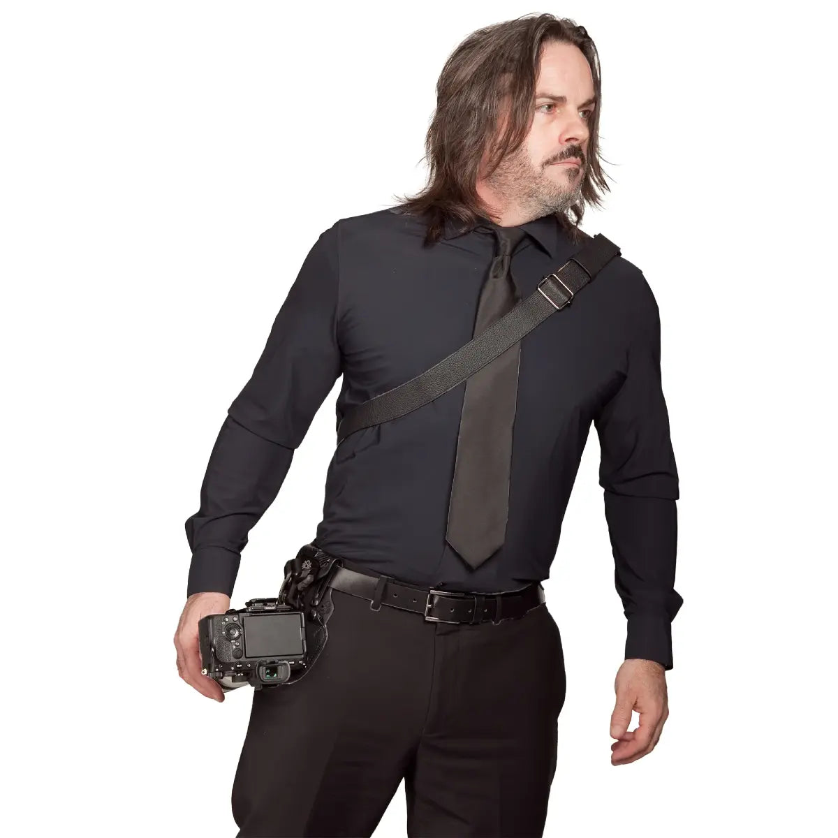 Man in a black shirt and pants holding a camera on a white background
