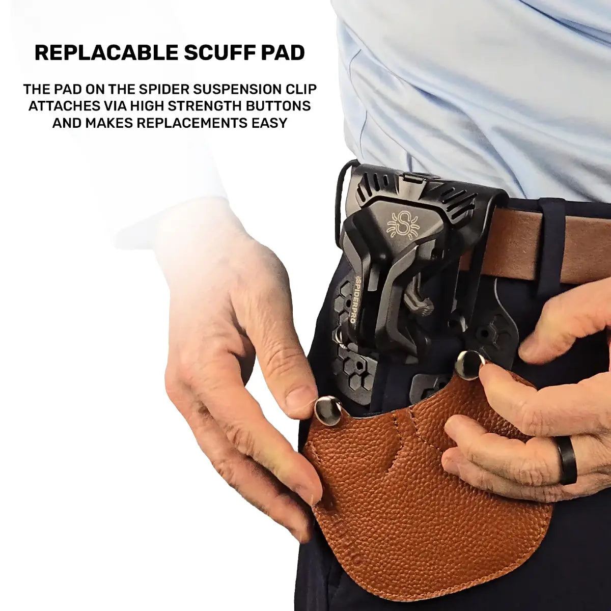 Person holding a leather holster with a spider suspension clip, emphasizing the replaceable scuff pad feature.