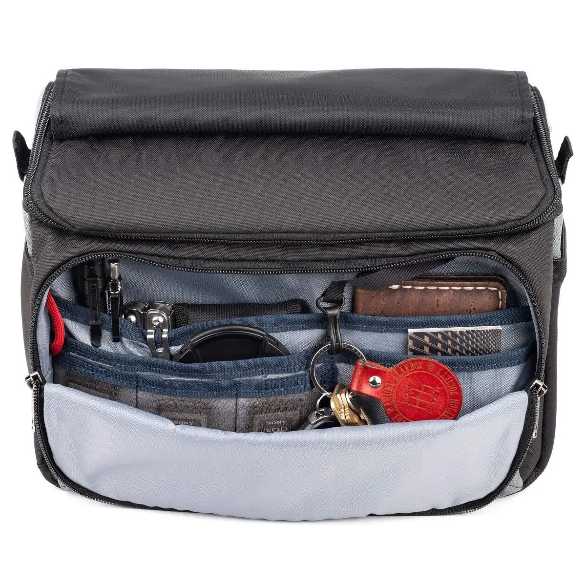 Open black bag with various items inside on a white background