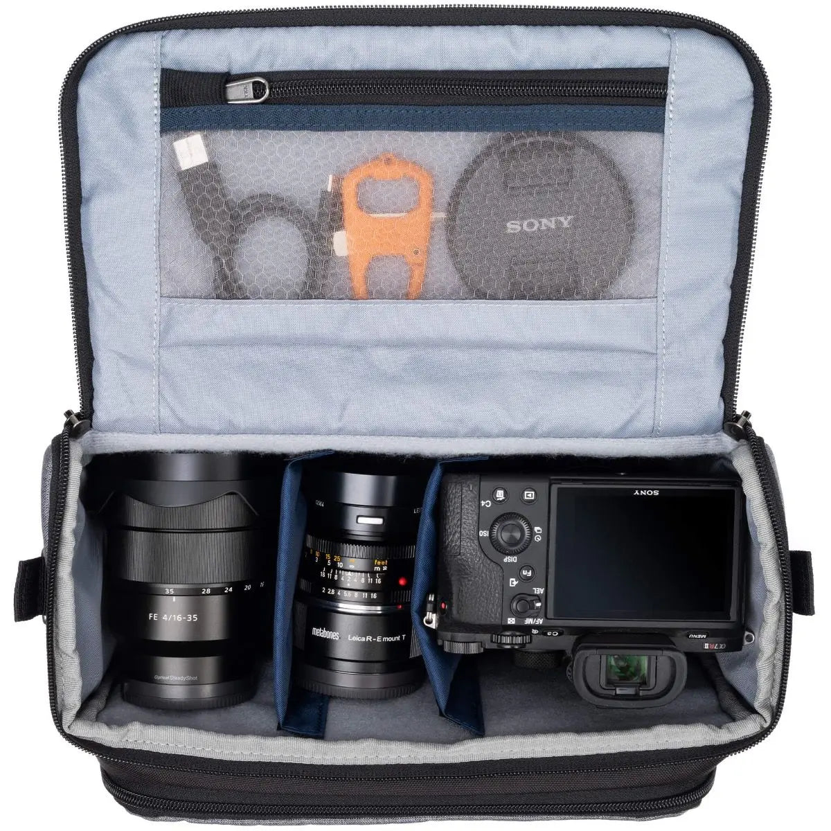 Camera bag with compartments for camera equipment, including lenses and a camera body.