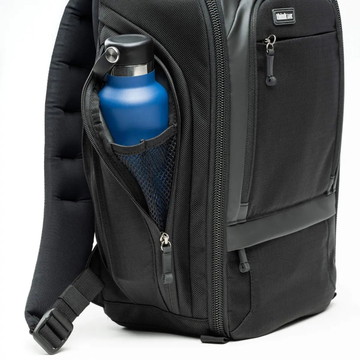 Black backpack with a blue water bottle in an open pocket on a white background