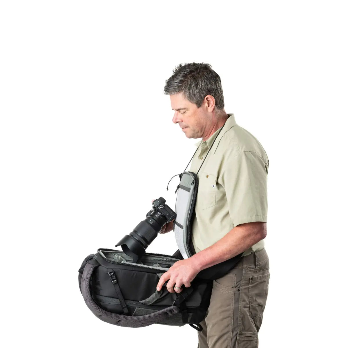 Man holding a large camera bag with a camera inside on a white background