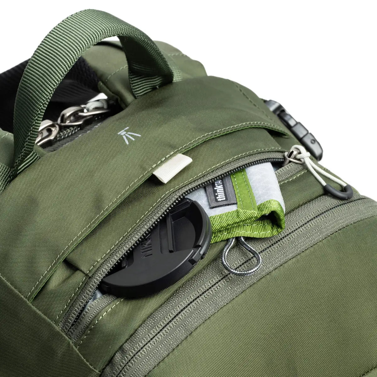 Close-up of a green backpack with zippers and straps on a white background