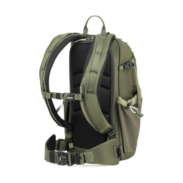 Green backpack with multiple straps and compartments on a white background